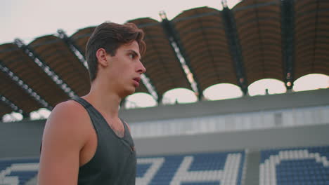 Ein-Speerwerfer-Läuft-Mit-Speeren-Durch-Das-Stadion-Und-Sammelt-Sie-Ein.-Gehen-Sie-Mit-Einem-Speer-In-Der-Hand-Vor-Dem-Hintergrund-Der-Stadiontribüne.-Das-Training-Des-Olympiasiegers.